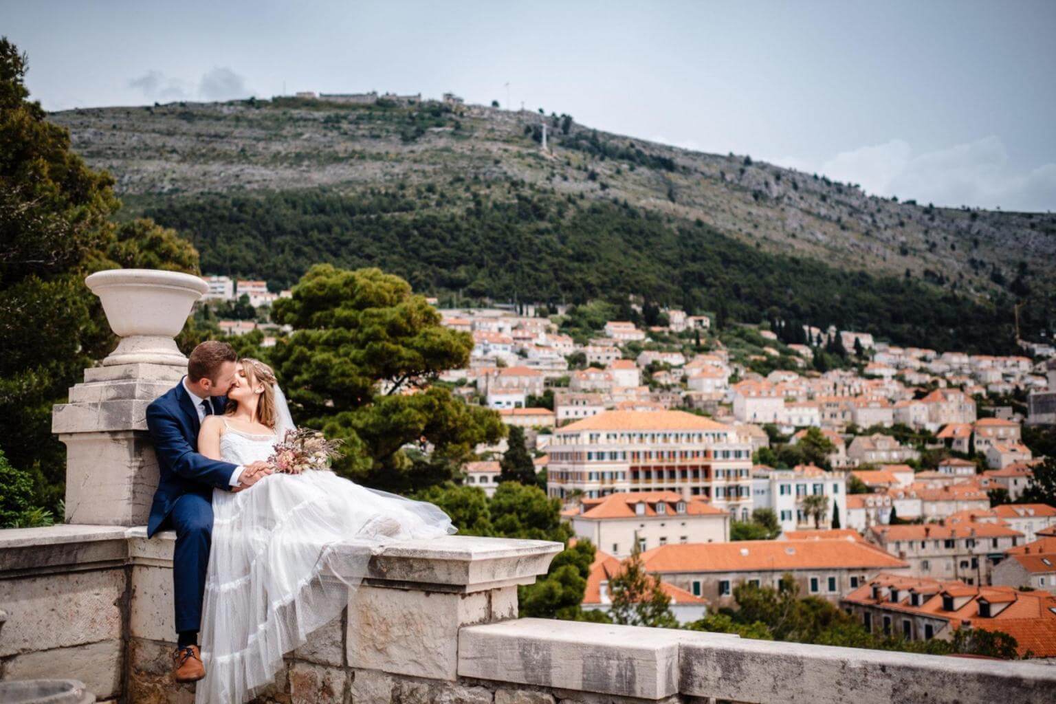 Brautpaar auf Mauer bei Hochzeit in Kroatien