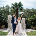 Brautpaar vor Palme und Traubogen mit Brautstrauß aus Schleierkraut Wedding Kroatien, wedding in croatia,hochzeitsplanerin kroatien, hochzeit in kroatien