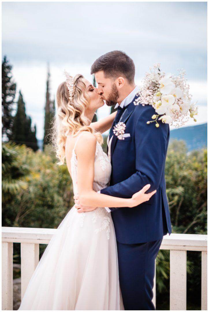 Brautpaar küsst sich mit Schleierkraut Brautstrauß auf Terrasse im Garten einer Villa in Kroatien hochkant Wedding Kroatien, wedding in croatia,hochzeitsplanerin kroatien, hochzeit in kroatien