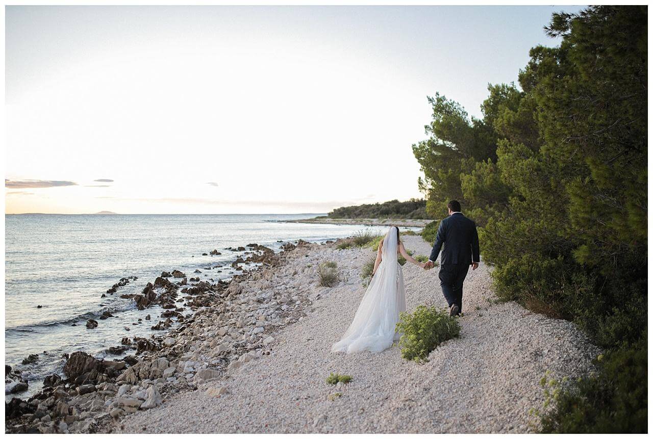 Brautpaar am Meer bei ihrer Hochzeit neben alten Leuchtturm in Kroatien