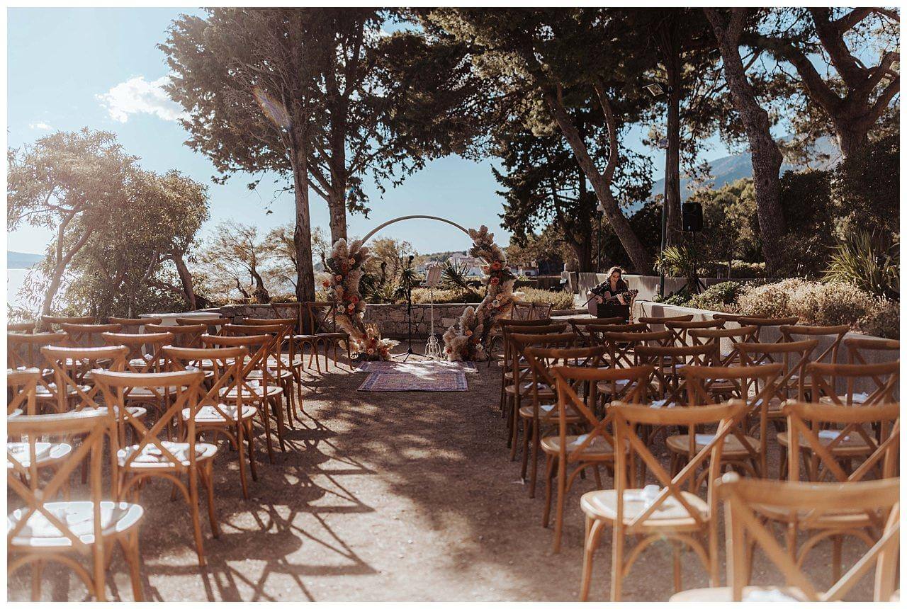 Traubogen aus Holz mit Blumen in neutralen Orange und beige tönen bei einer Hochzeit auf der Insel Brac in Kroatien
