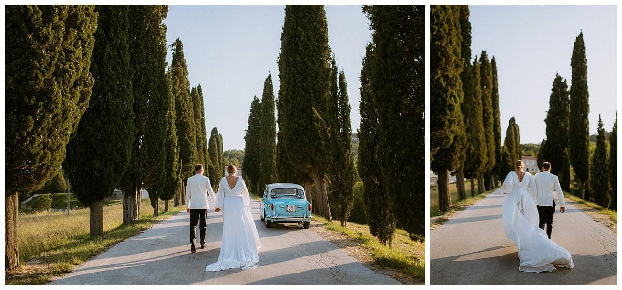 Brautpaar in weiß auf einen abgelegenen Gehweg mit Bäumen bei ihrer Hochzeit in Istrien Kroatien