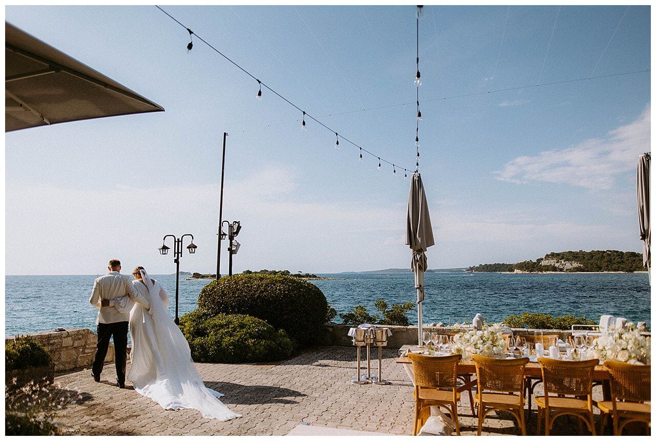 Brautpaar in weiß mit dem Blick aufs Meer bei ihrer Hochzeit in Istrien Kroatien