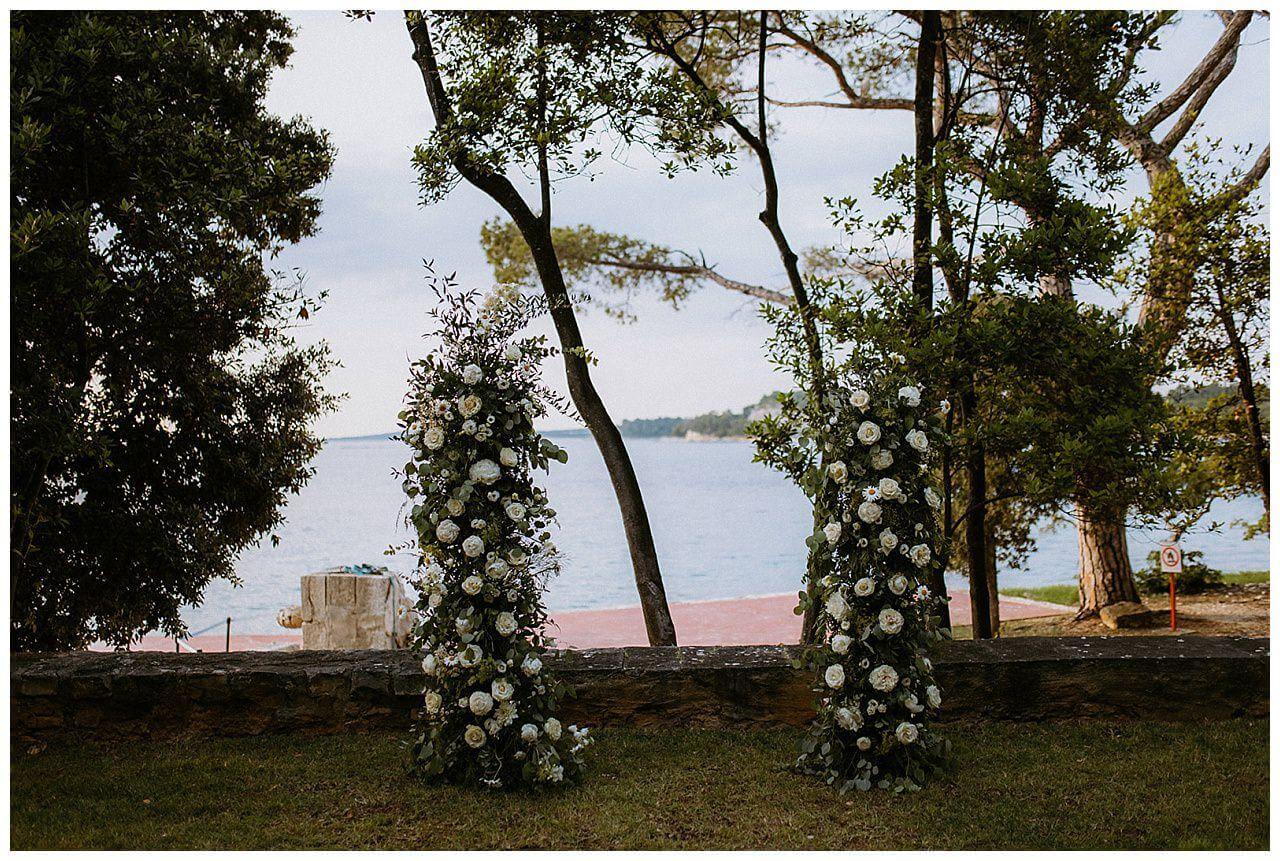 Traubogen nur aus blättern und weißen Rosen bei einer Hochzeit in Istrien in Kroatien