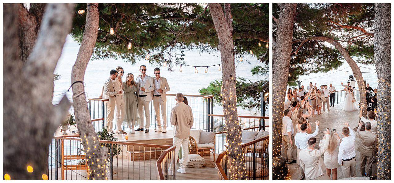 Brautpaar und Gäste auf Terrasse mit dem Blick aufs Meer bei ihrer Hochzeit in Kroatien