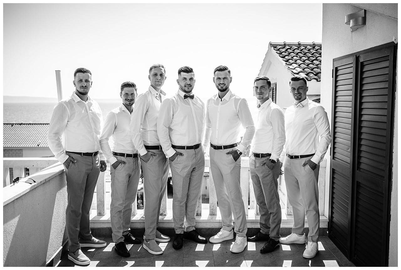 Bräutigam und Freunde bei auf Balkon schwarz weiß bei seiner Hochzeit in Kroatien