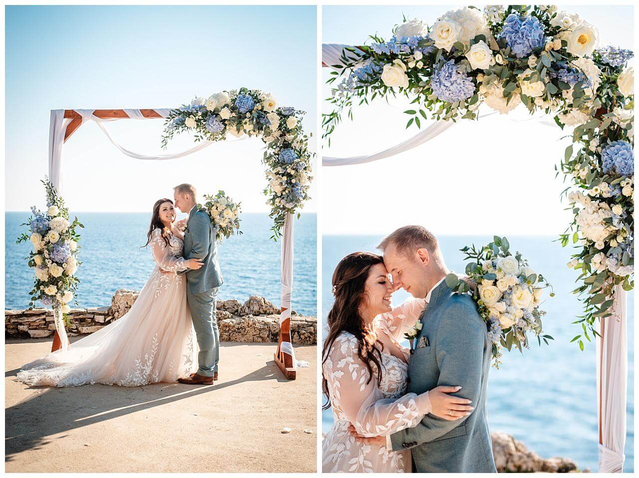 Brautpaar vor Traubogen aus Holz und weißer Stoffe Blau weißer Blumendekoration mit dem Blick aufs Meer bei einer Hochzeit in einer privaten Finka