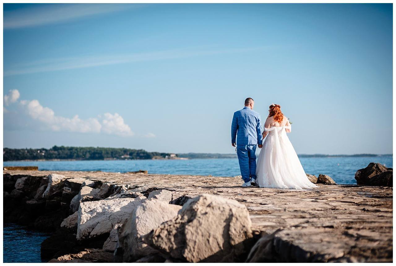 Brautpaar auf einem Steinweg im Meer bei ihrer Hochzeit in Kroatien