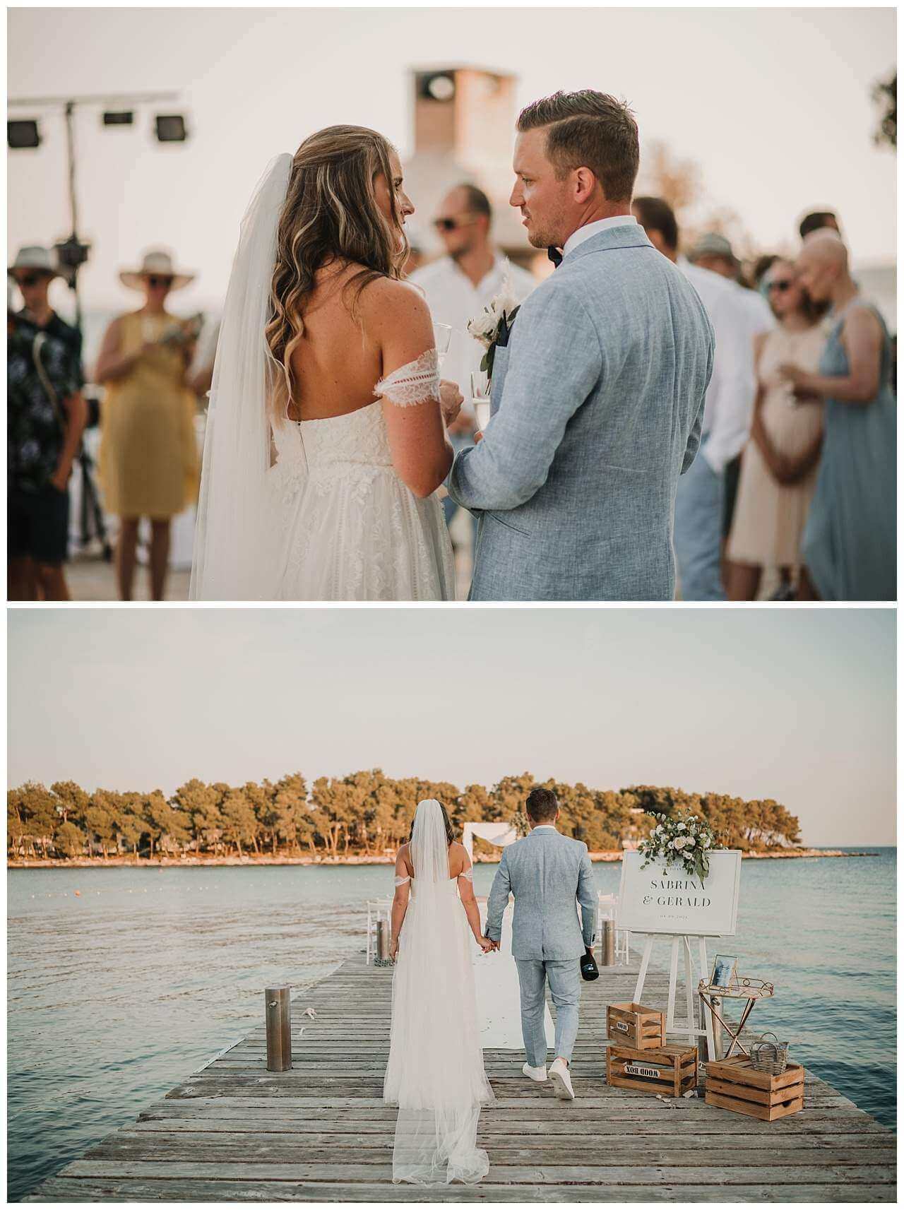 Brautpaar vor Gästen und auf Steg im Gegenlicht bei Hochzeit am Yachthafen in Kroatien