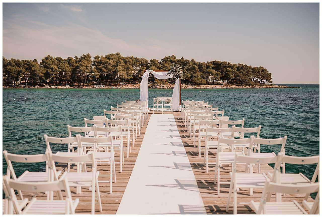 Trauungssetting mit Traubogen und Stühlen bei Hochzeit am Yachthafen in Kroatien